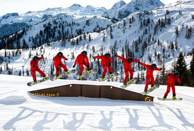 群人在红夹克和裤子站在冰雪覆盖的地面白天
